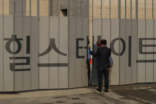 22일 오후 경기도 남양주시 다산신도시 공사현장에서 타워 크레인이 쓰러지는 사고가 발행하자 공사 관계자가 취재진의 접근을 막고 있다. 연합뉴스
